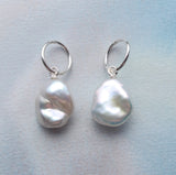Enhance your jewelry collection with our cultured freshwater Keshi pearl earrings on sterling silver sleeper hoops. These genuine freshwater pearls are expertly cultured and grown in mussels found in pristine freshwater ponds, lakes, and rivers. Taking between two to six years to mature, each pearl is handpicked for its unique shape and tone, ensuring no two pairs are alike.